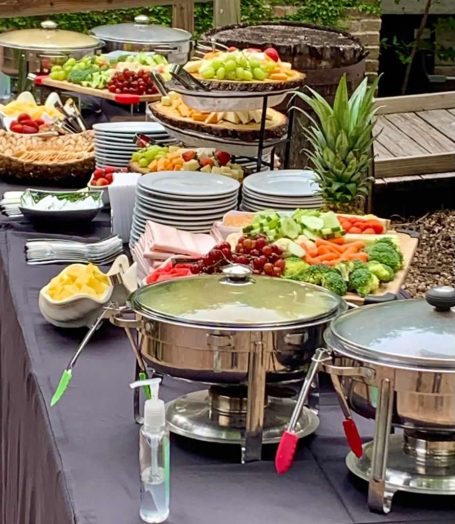 Grazing Table A buffet table featuring a variety of salads, fruits, and vegetables with serving dishes.