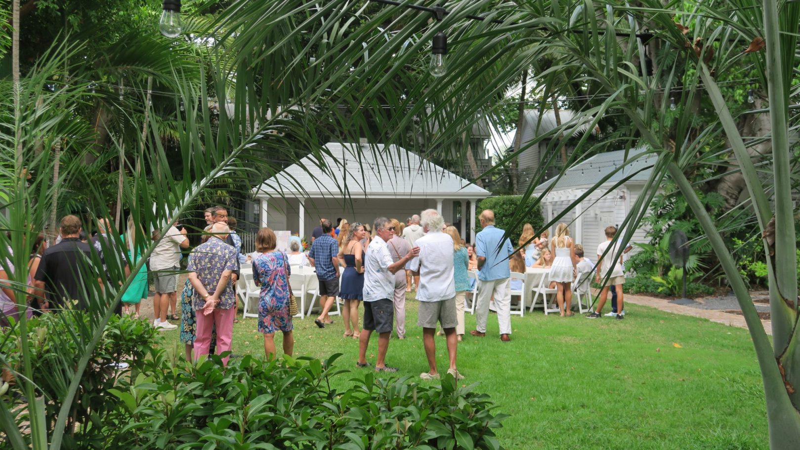 Oldest House Garden Repass! A gathering of people in a lush garden near a gazebo surrounded by greenery.