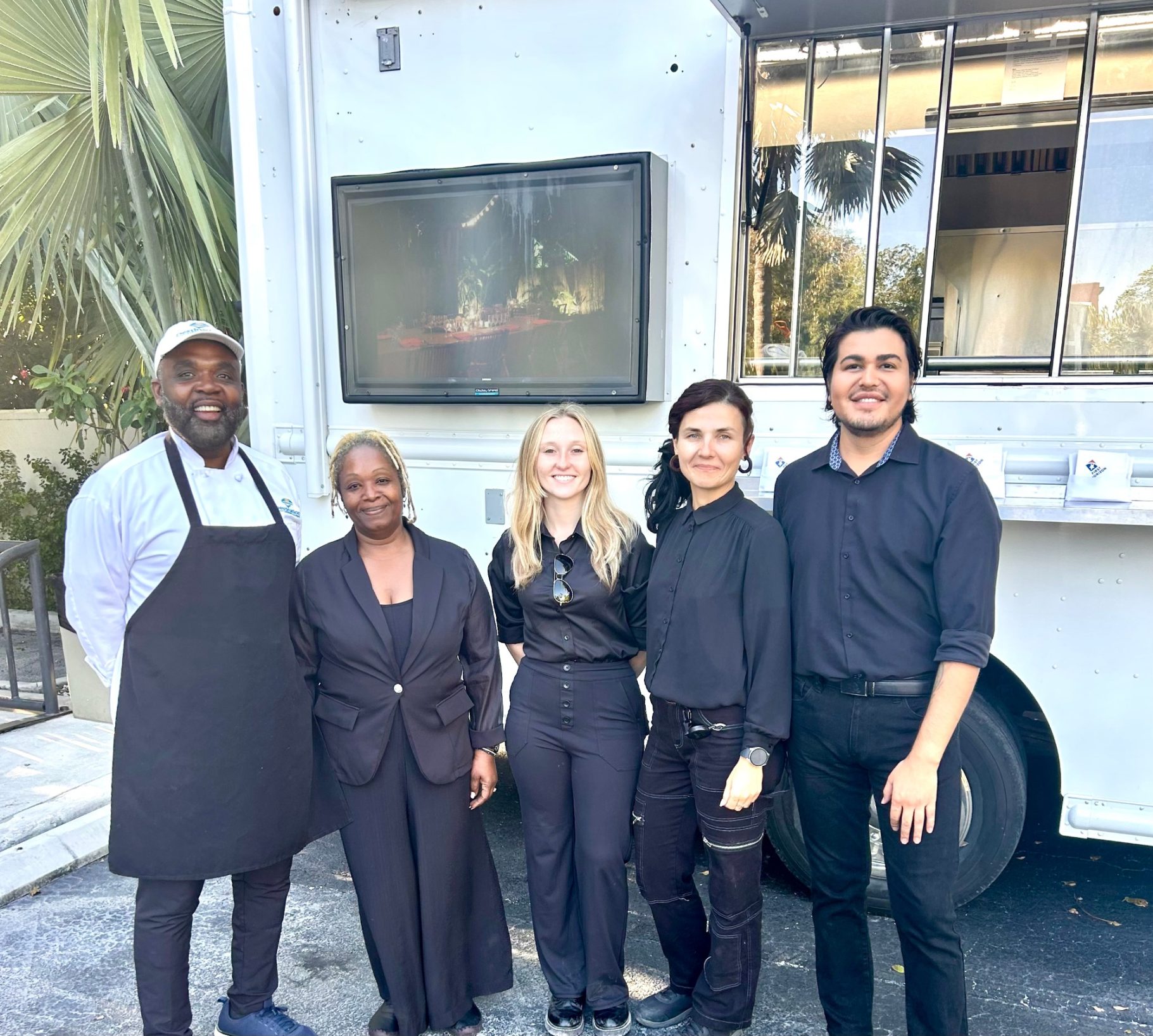 Key West Corporate Event Destination Catering & Events posing together, smiling in front of the catering truck.