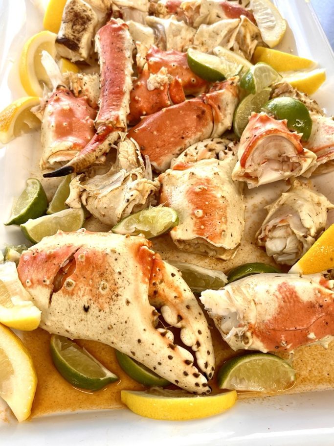 Key West Seafood Cooked crab clusters garnished with lemon and lime slices on a white platter.