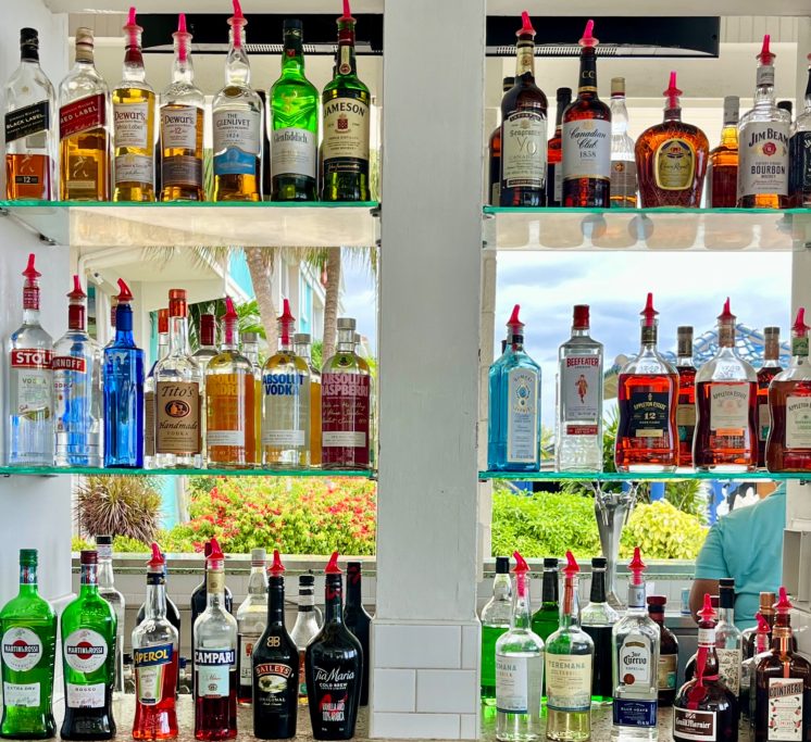 Island Bar Shelf filled with various liquor bottles in a bar setting.