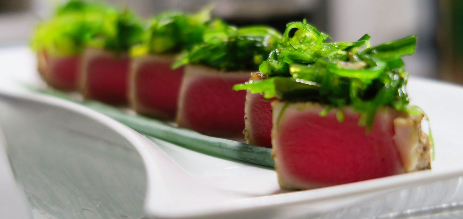 Ahi Tuna, with seaweed salad Sliced sesame seared tuna topped with seaweed salad. A Destination Catering & Events beloved Hors D'oeuvre for cocktail parties.